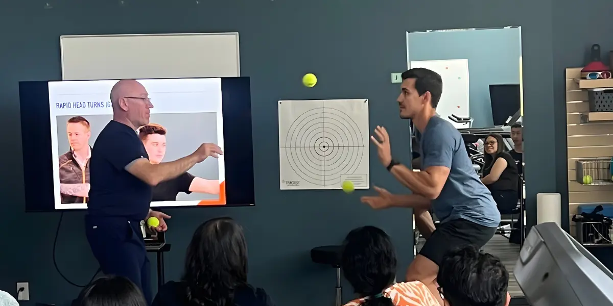 Healthcare providers practicing hands-on concussion assessment techniques in live workshop